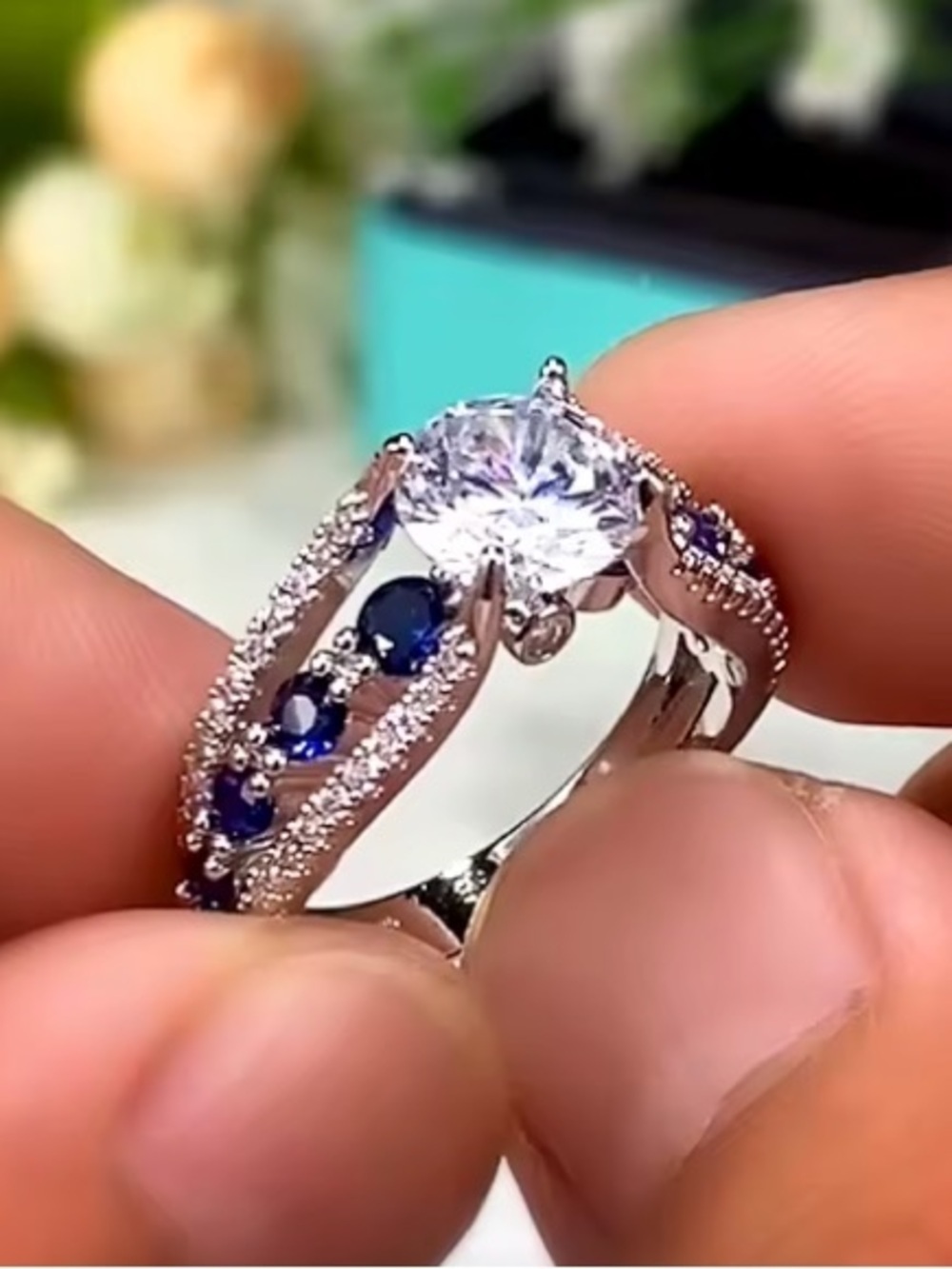 Silver Ring with Deep Blue Stones and Clear Center Gem.